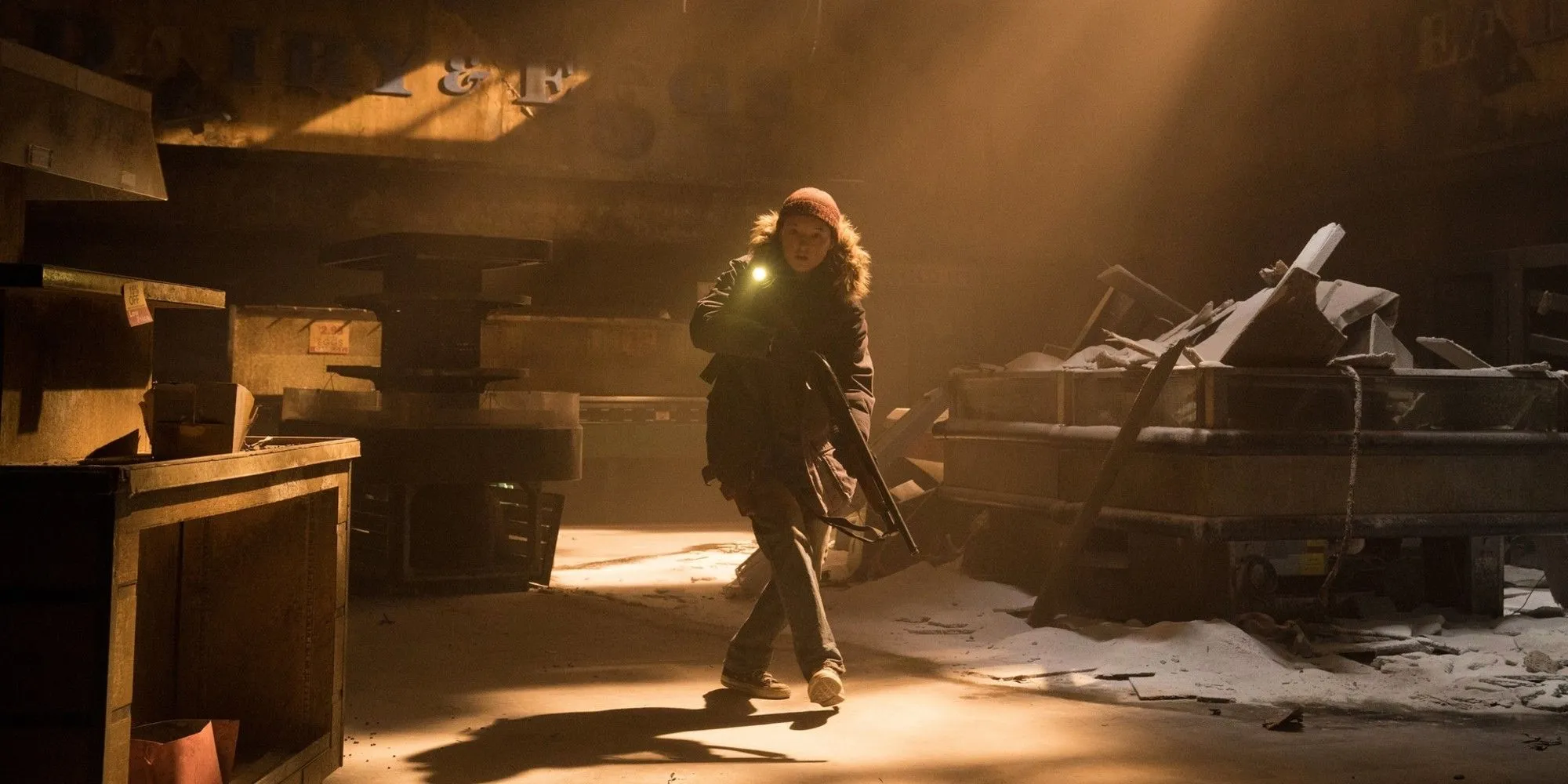 Ellie cầm súng khám phá một tòa nhà hoang tàn trong The Last of Us Mùa 2, minh họa hành trình sinh tồn đầy thử thách.