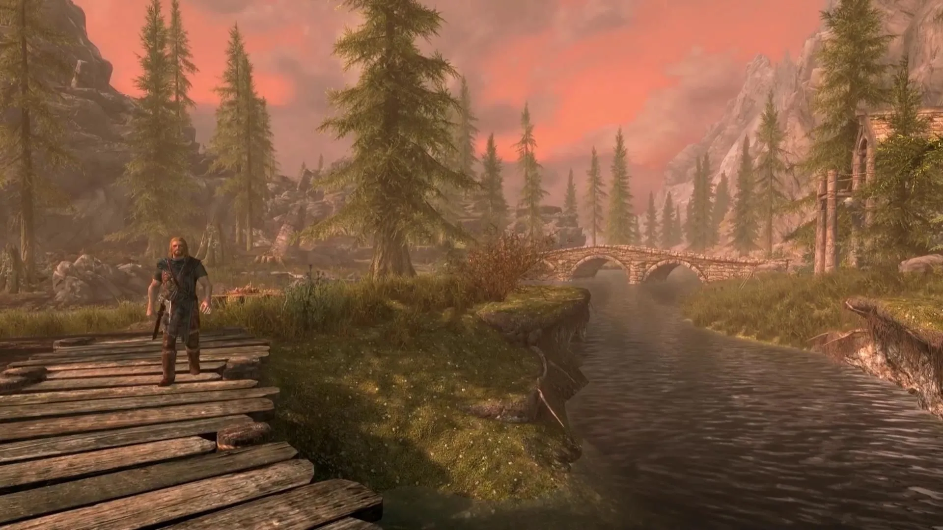 Khung cảnh bình yên của Riverwood trong The Elder Scrolls V Skyrim, cây cầu gỗ bắc qua sông, thể hiện sự bao la của thế giới game.